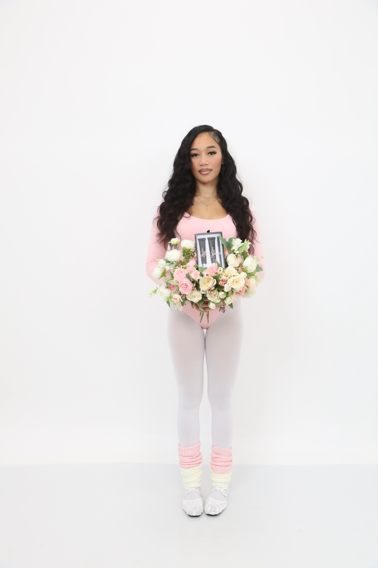 ASIA SMITH BEAUTY founder holding a floral arrangement and lip kit
